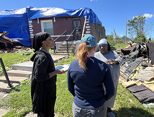 Joint Preliminary Damage Assessment team members gather information from a North St. Louis resident during damage assessments on May 21, 2025, following an EF-3 tornado on May 16.